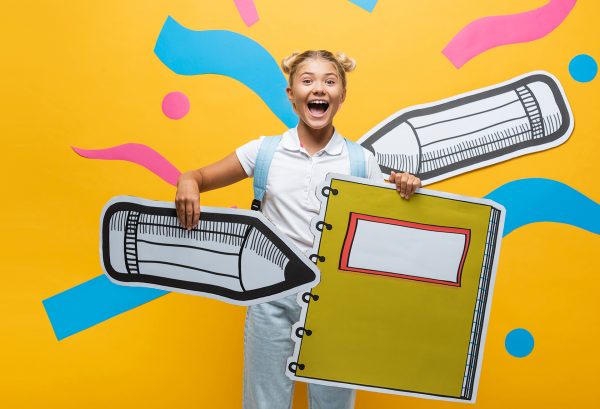 young girl holding a cartoon pencil and journal
